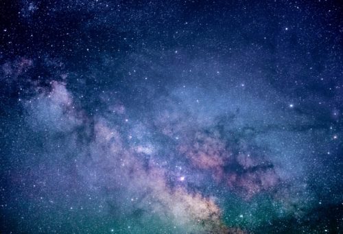 Outer space with stars and purple, white and green clouds