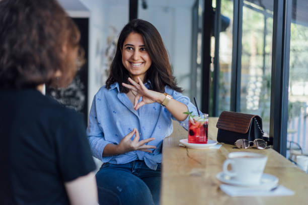 Two women smiling and speaking in sign language