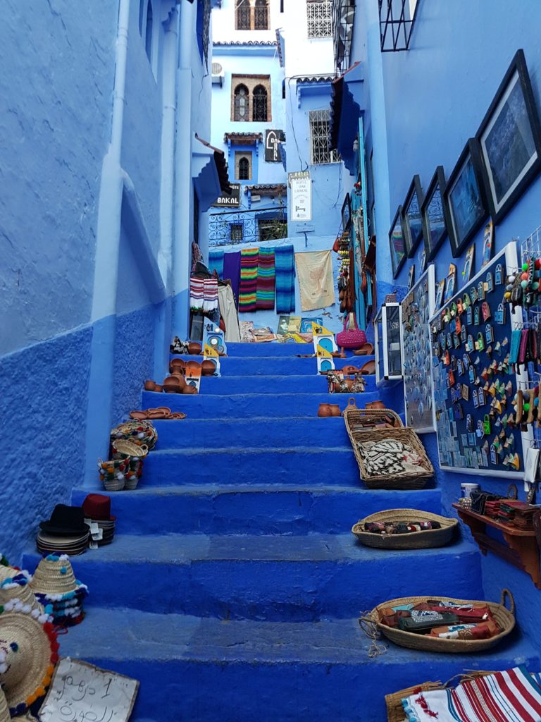 Blue stairs covered in straw baskets full of handmade items