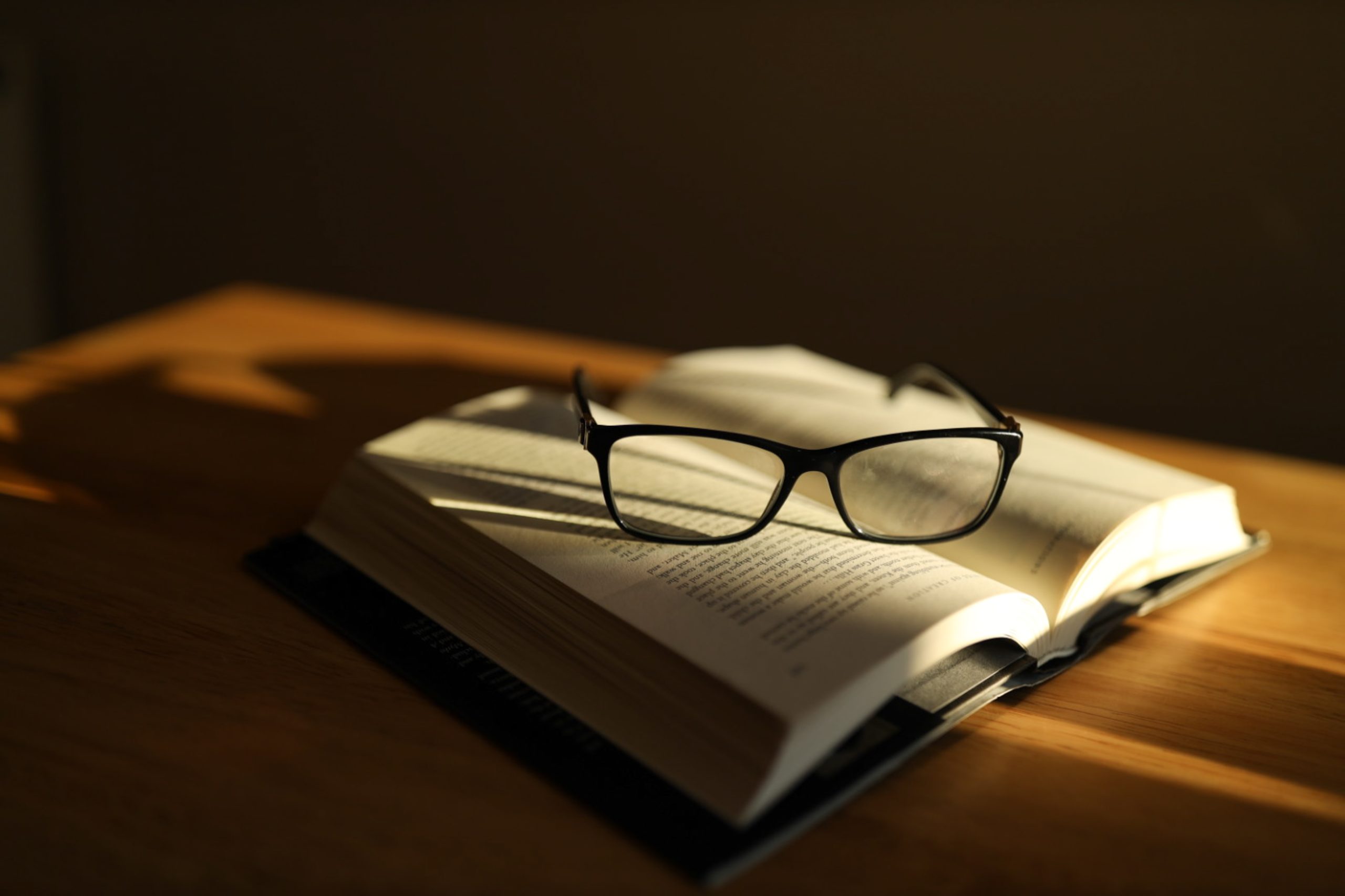 An open book with a pair of black glasses