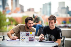 Students studying outside with the Denver skyline in the background