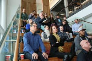 People sitting on a staircase in the AES Building for a presentation