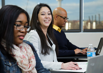 A student smiling toward the camera in class