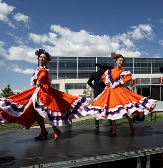 Two folklorico dancers in traditional folklorico dresses