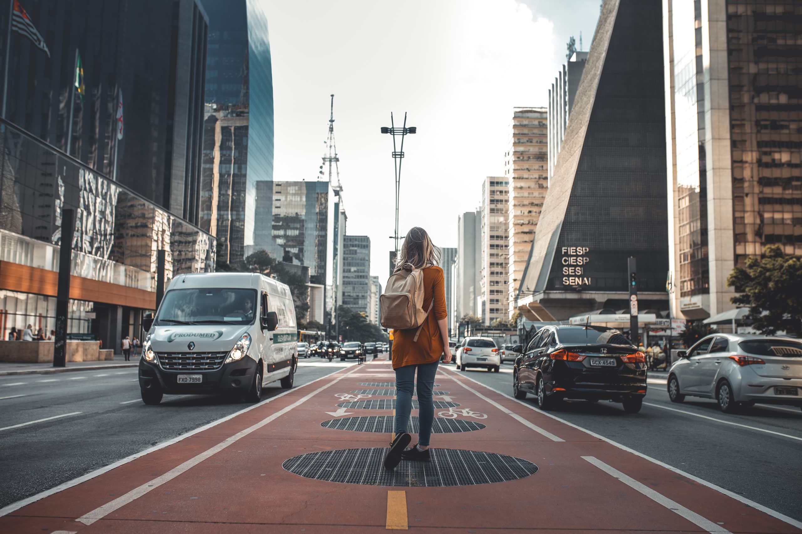 Photo of a women standing in the middle of a big city