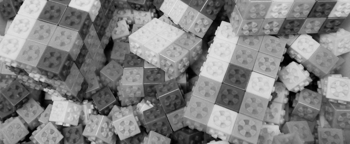 Black and white image of a pile of children's lego-style bricks.