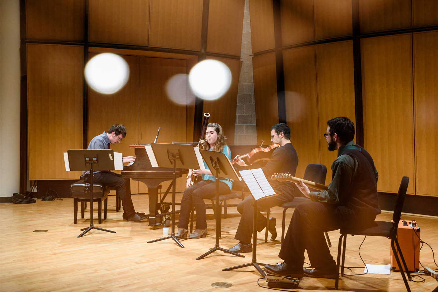 Chamber music group performing with piano, bassoon, violin, and guitar
