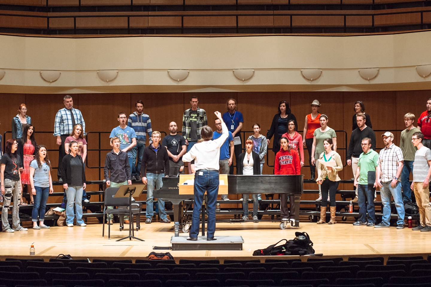 Choral conductor leading a choir rehearsal in the King Center Concert Hall