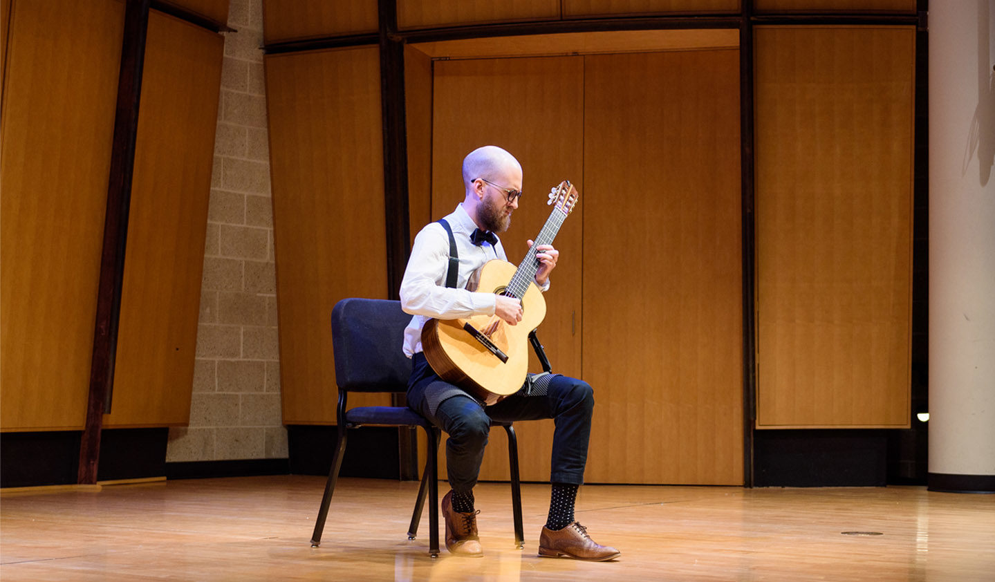Classical guitarist performing solo in the King Center Recital Hall