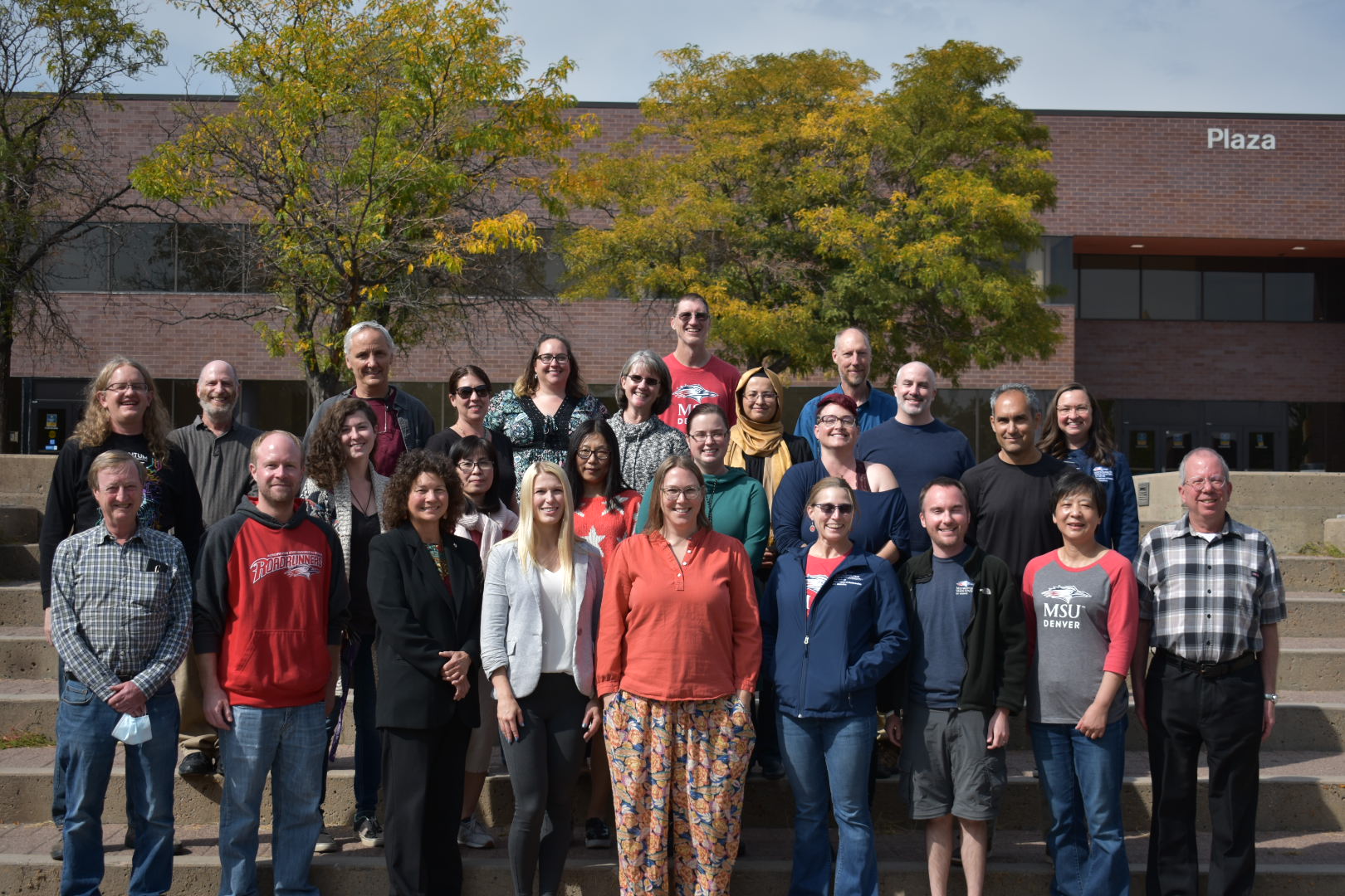 Department of Math and Statistics faculty smiling in front of the Plaza Building