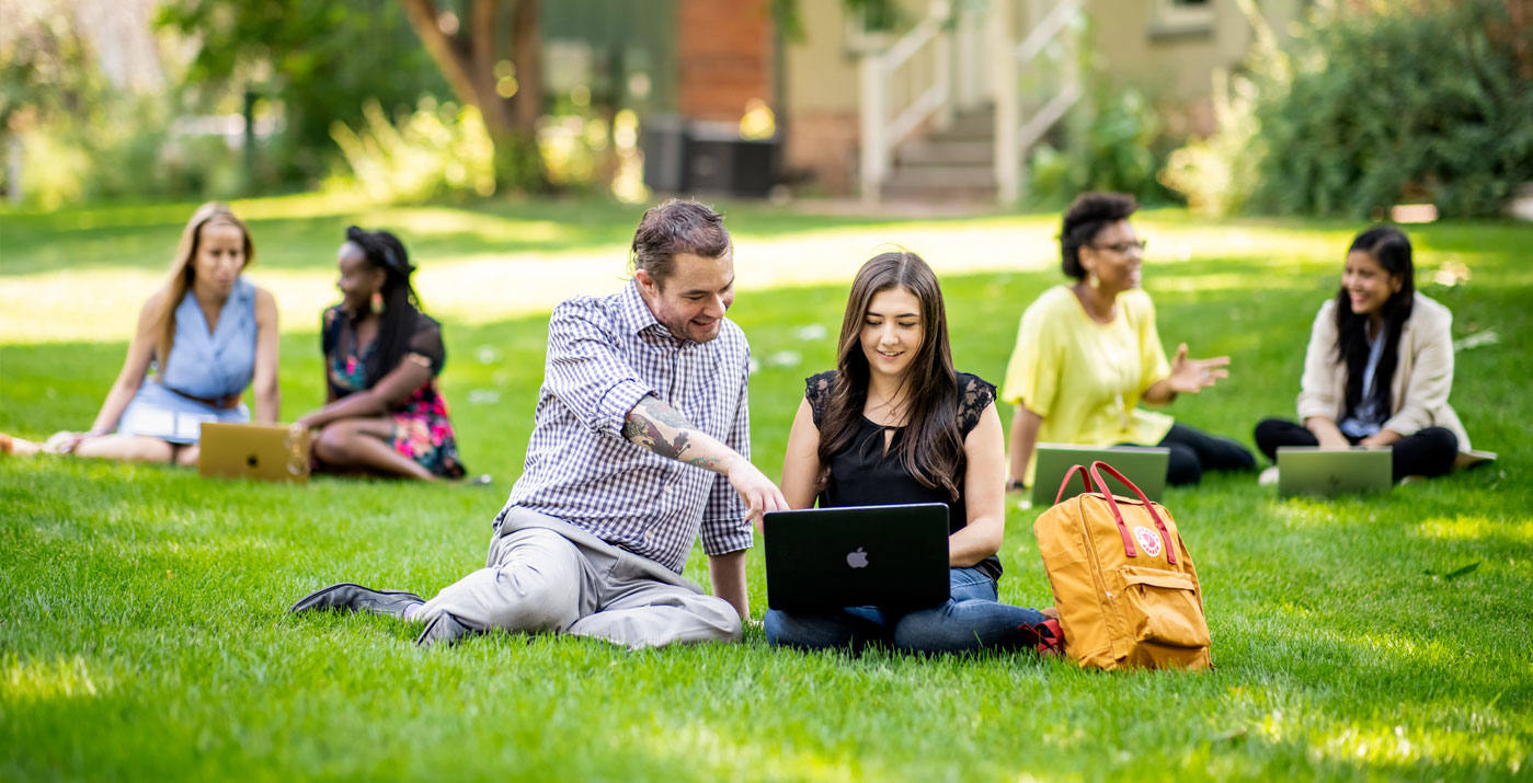 Image shows MHA students outside working together on a computer. The image is decorative.