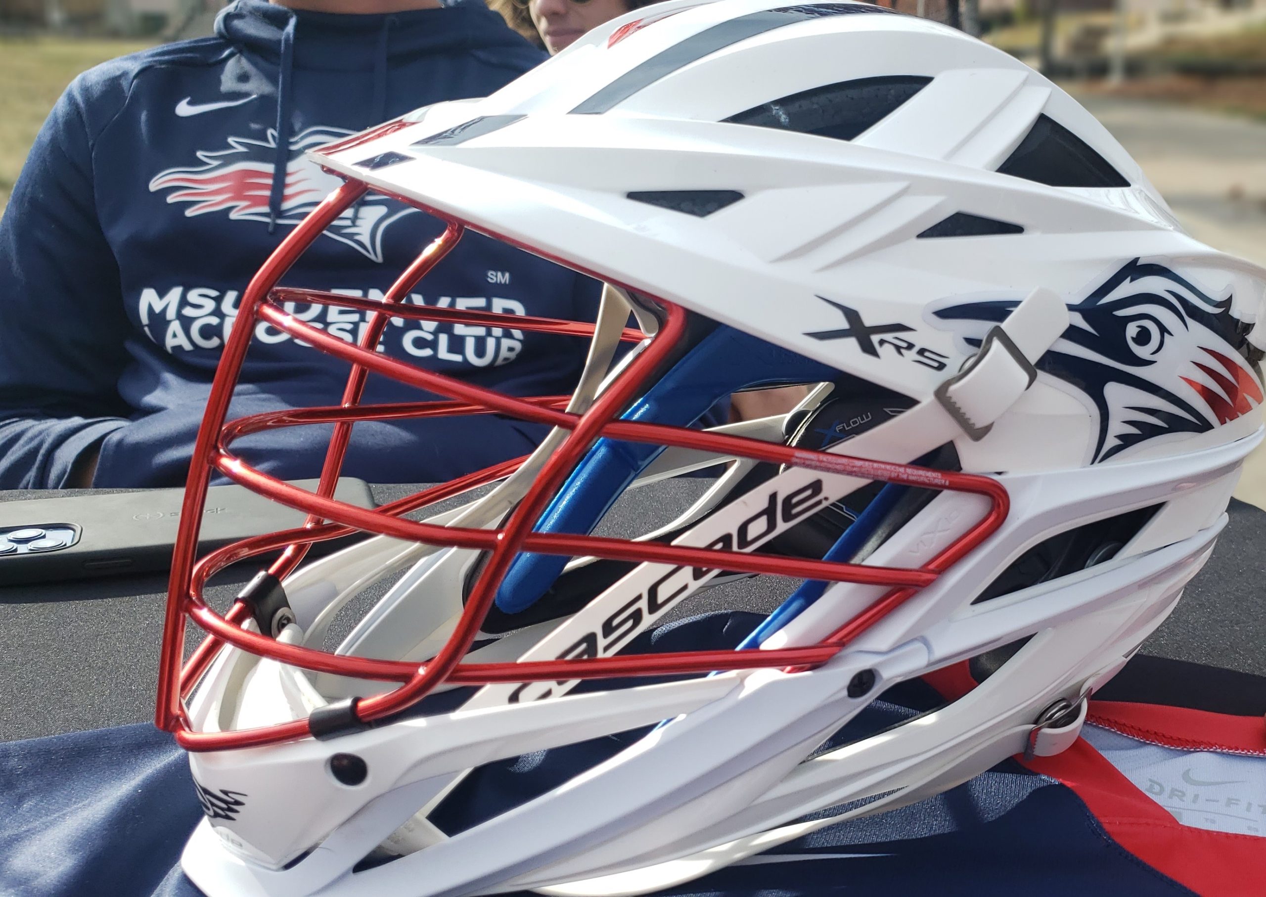 A Club Lacrosse helmet sitting on a table