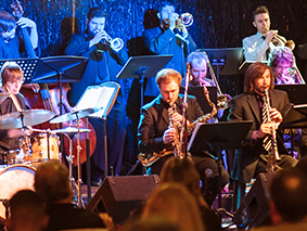 MSU Denver Big Band horn section performing in colorful lights