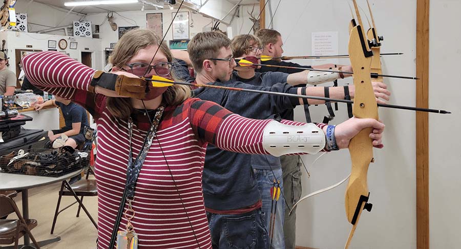 students with bows drawn at the archery lanes