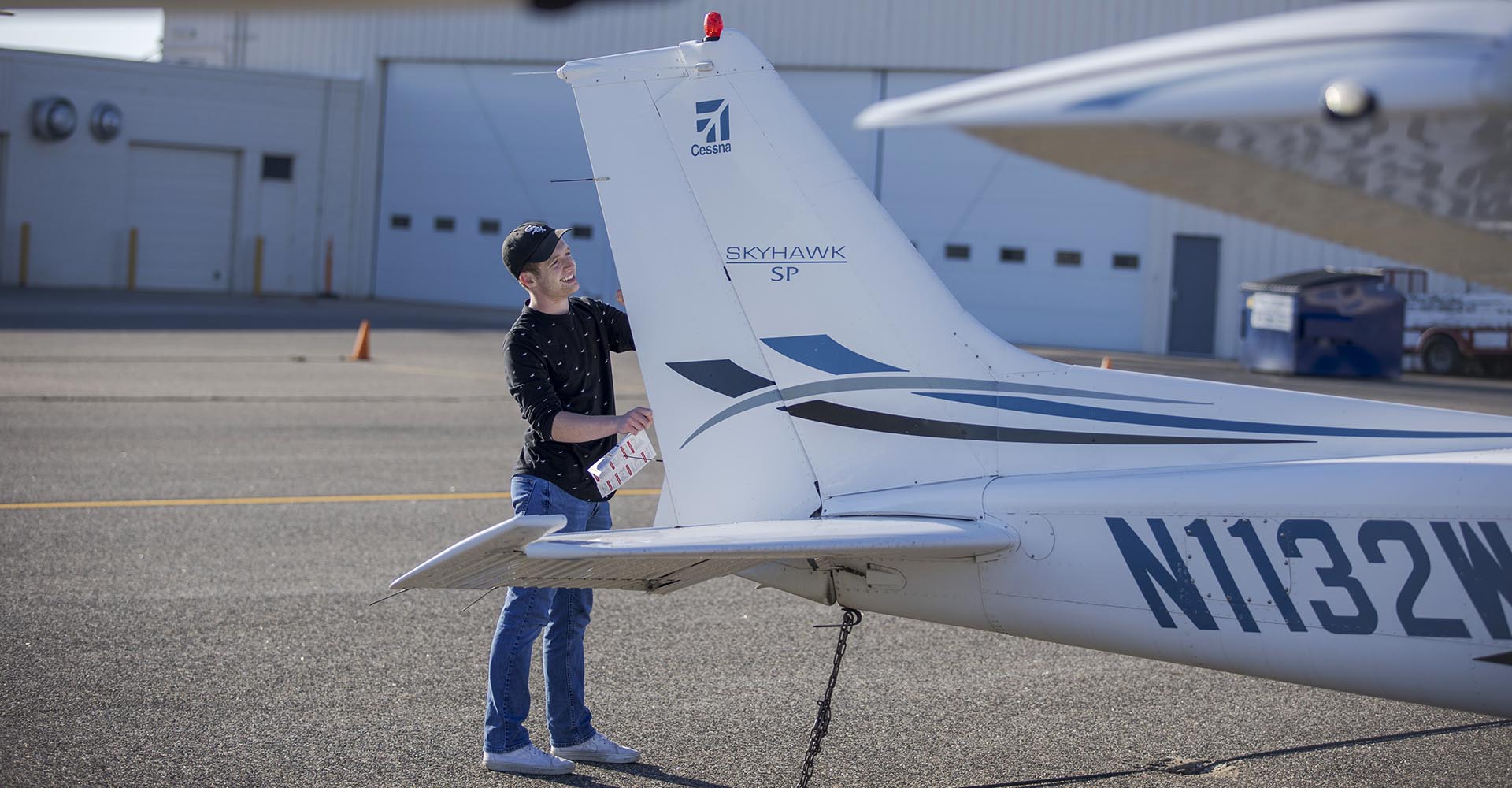 Aviation student Declan Kreck works on an airplane's tail
