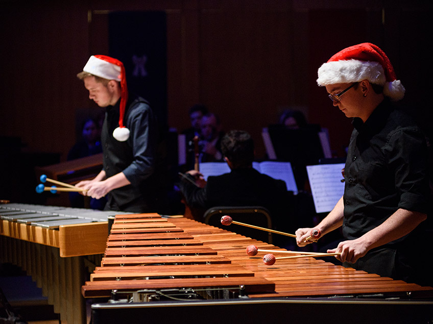 Two marimba players in Santa hats performing