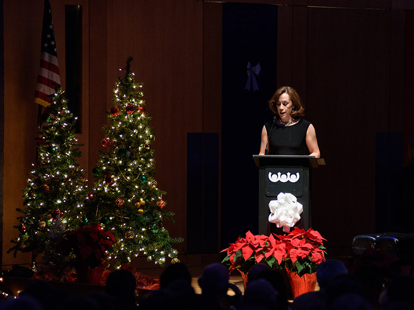 President Janine Davidson reading onstage at Holiday Card to the City