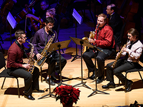 Saxophone quartet performing on stage in blue light