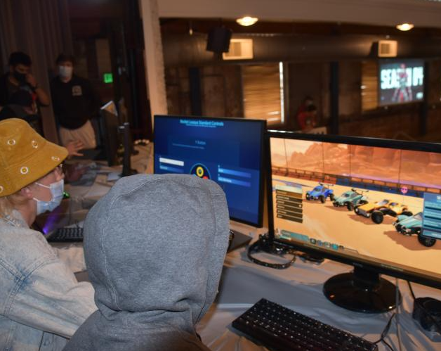 Two students playing a video game on the stage in the Tivoli Turnhalle