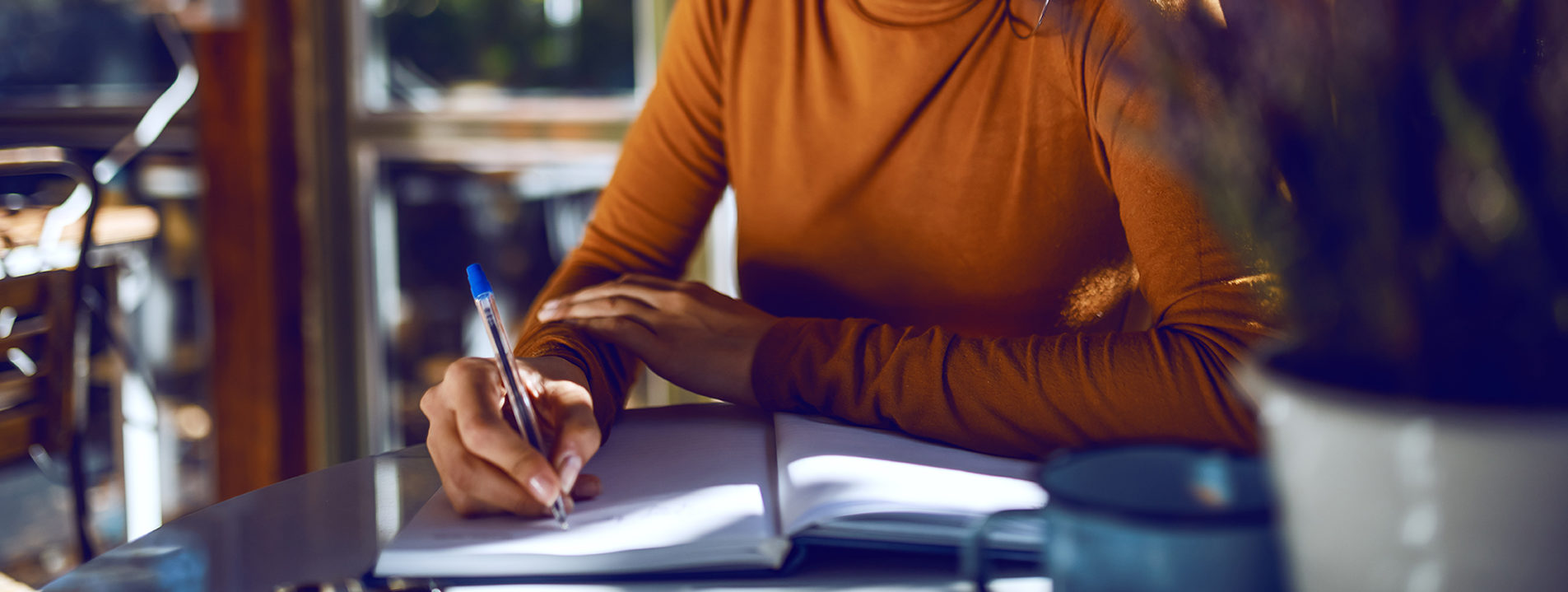 Close up of woman writing in notebook