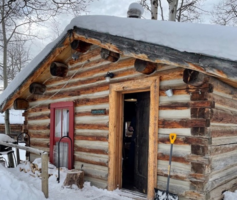 photo of a snow-covered log cabin