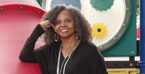 Dr. Rosemarie Allen standing in front of a playground.