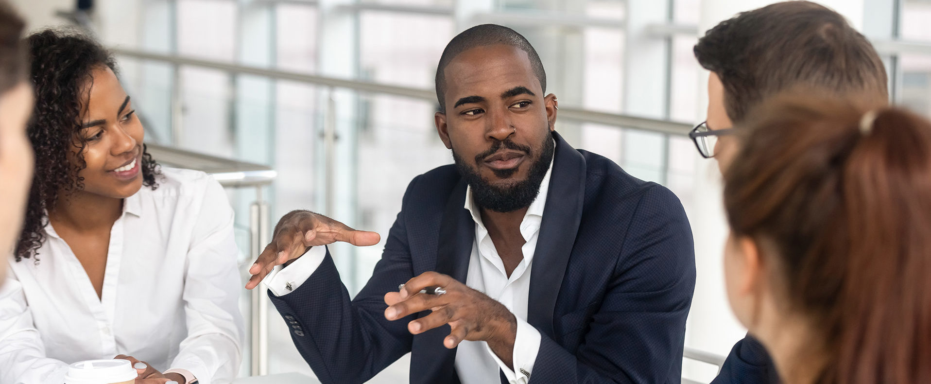 Millennial employees gathered in boardroom for training, black boss ceo leader leading corporate team during seminar learning at modern office. Internship and leadership coaching and education concept