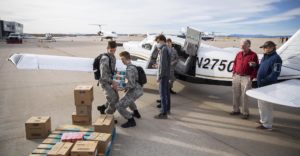 Flight team loading donation items into an airplane