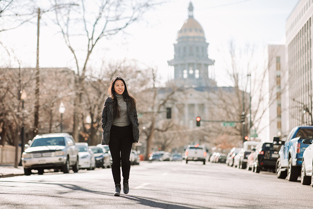 Student Li Chen Chen walking with Colorado Capitol dome behind her