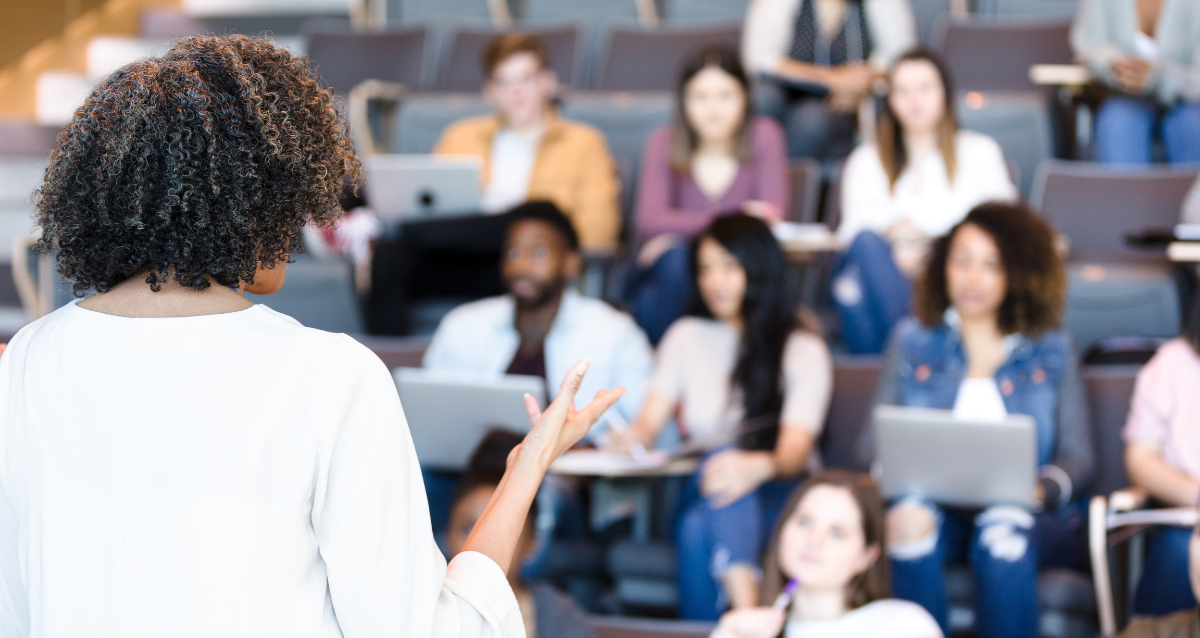 Professor presenting to a group of students on risers.