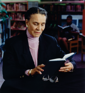 Rachel Noel reading a book in a library