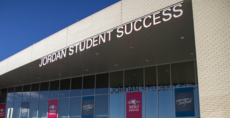 Jordan Student Success building sign above a row of MSU Denver signs hung on windows above JSSB entrance.