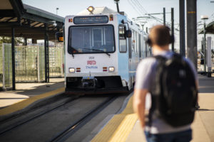 Man waiting for an approaching RTD light rail.