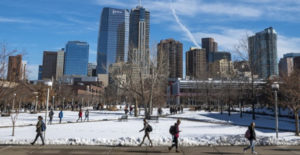 Roadrunners walking on campus in wintertime. Denver cityscape in background.