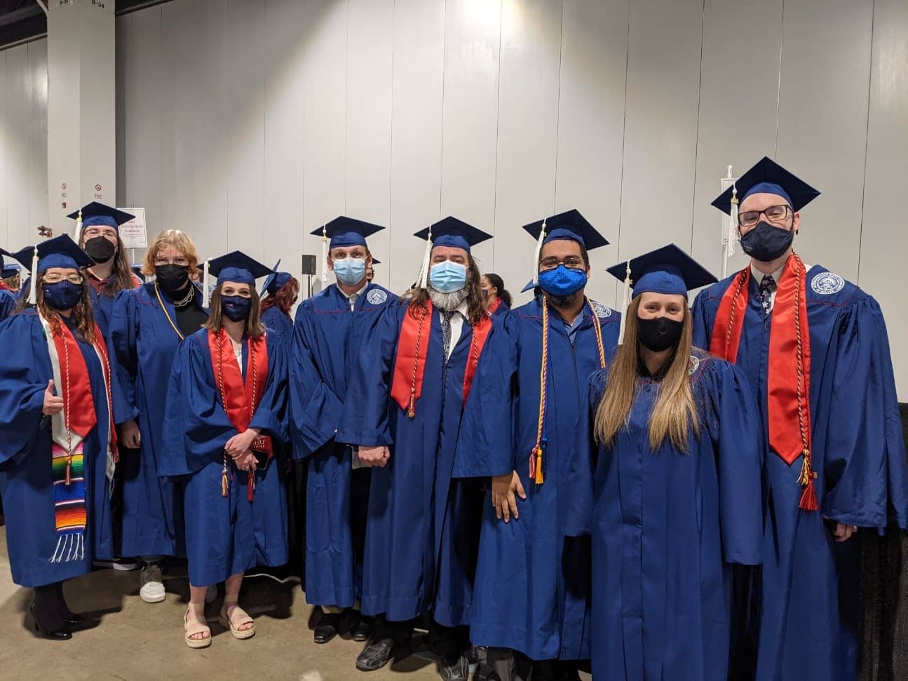 Masked students in regalia on graduation day