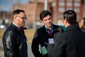 Students in professional clothing talking outside.