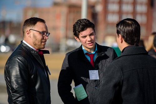 Students in professional clothing talking outside.