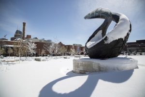 One Water statue in snow; Tivoli building background.