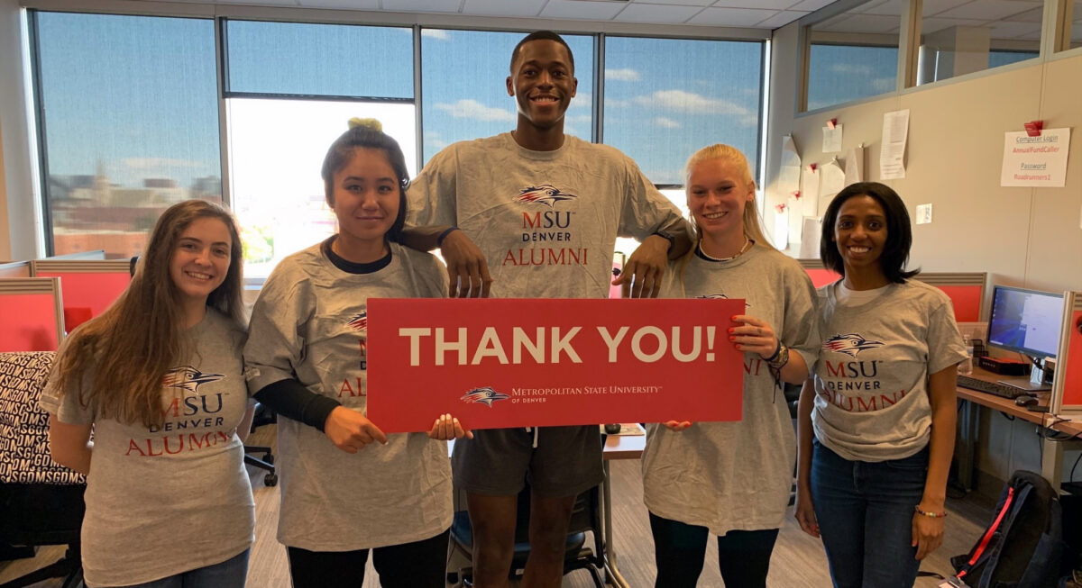 group of five students holding a thank you sign