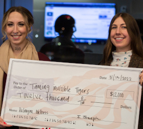 Hannah Sheridan and Barrie Mack holding a giant printed check for their $12000 award.