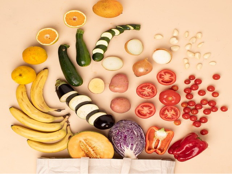 canvas bag with produce neatly spilling out arranged by color