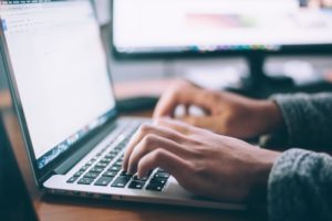 Person typing on a Macbook laptop