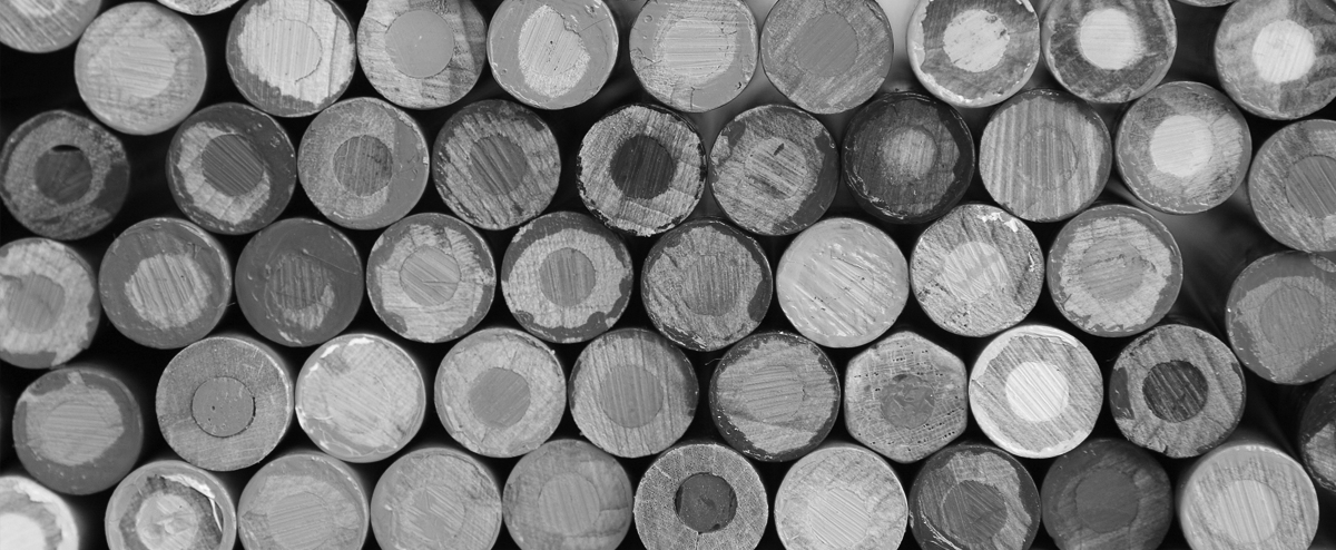 Close up black and white photo of the bottoms of a bundle of colored pencils.