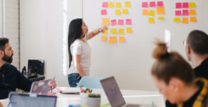 Woman pointing to a vision board in a meeting.