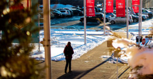 Student walking to parking lot on a snow covered campus.