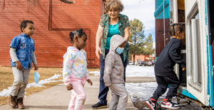 Roya Brown helping preschoolers step into the mobile classroom.