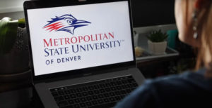 A student working from home with the MSU Denver logo displayed on her laptop.