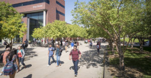 Students walking across campus in front of the King Center building