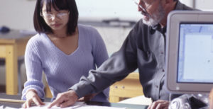 Teacher and student reviewing a paper together.