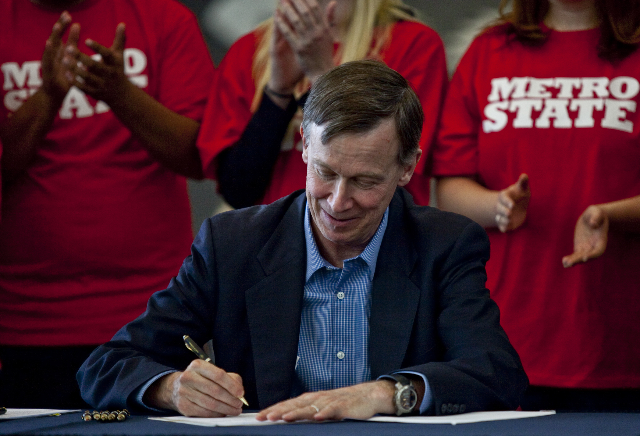 Gov. John Hickenlooper signs bill in Lobby of Student Success Building, Dr. Jordan, University President, VIPs, Rowdy and students watch event.